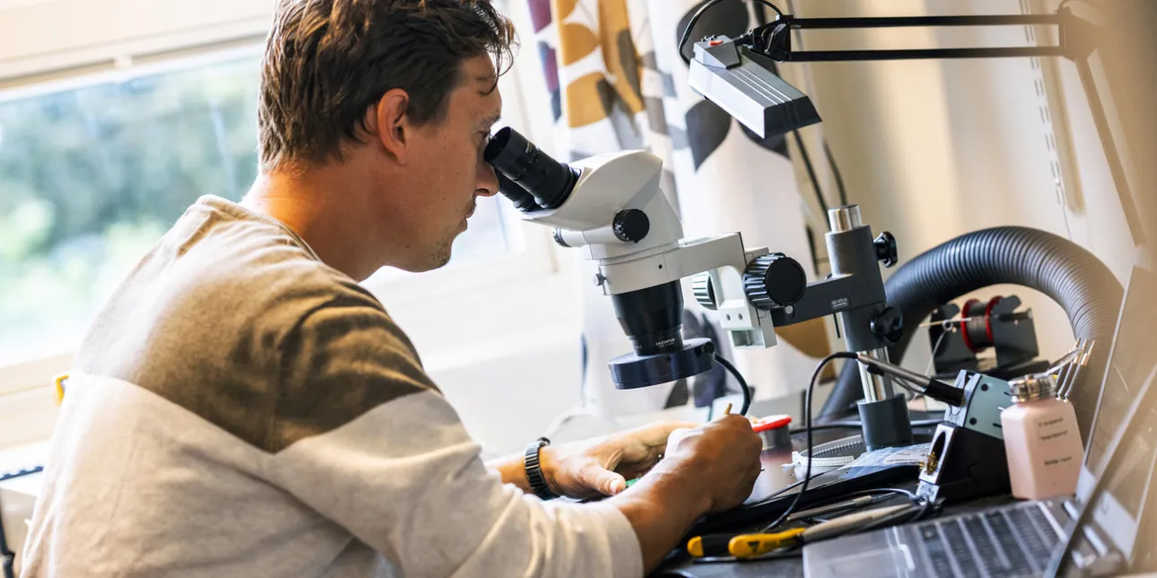 Researcher looking in microscope. Photo.
