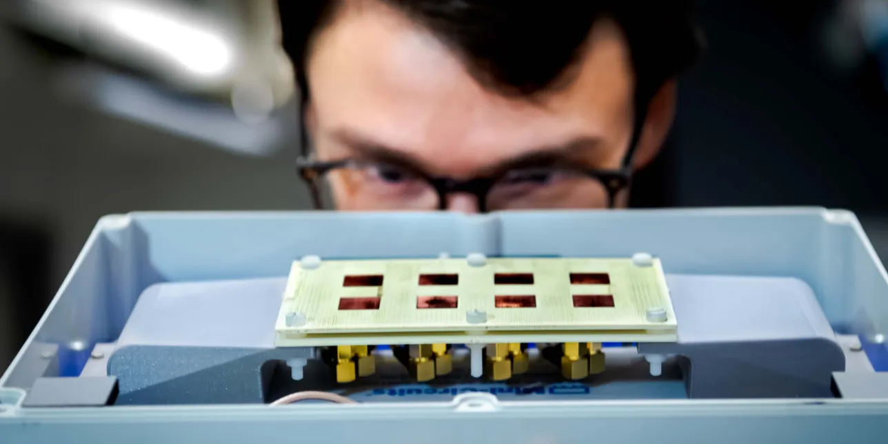 Researcher looking at electronic lab equipment. Photo.